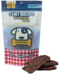 A package of Saint Rocco's Backyard BBQ Cheeseburger dog treats with several pieces of the dark brown jerky displayed in front on a white background.